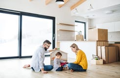A portrait of young family with a toddler girl moving in new home. stock photo A portrait of young family with a toddler girl moving in new home. stock photo