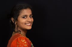 Portrait of a happy young Indian girl smiling on black background.