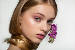 Portrait haut ?troit de jeune fille avec des yeux bleus, maquillage lumineux, cou envelopp? dans les cheveux, fleurs pourpres cou images libres de droits Portrait haut ?troit de jeune fille avec des yeux bleus, maquillage lumineux, cou envelopp? dans les cheveux, fleurs pourpres cou images libres de droits