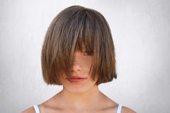Portrait horizontal du petit enfant féminin couvert de taches de rousseur couvrant son visage de cheveux tout en portant en équil Photographie stock Portrait horizontal du petit enfant féminin couvert de taches de rousseur couvrant son visage de cheveux tout en portant en équil Photographie stock