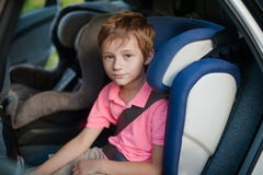 Portrait le garçon s'assied dans un siège de voiture image stock Portrait le garçon s'assied dans un siège de voiture image stock