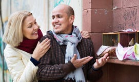 Portrait of loving mature couple feeding birds in cage Royalty Free Stock Photography Portrait of loving mature couple feeding birds in cage Royalty Free Stock Photography