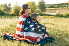 Portrait of mother and child daughter with American flag. Looking at natural rural landscape,view from the back stock image Portrait of mother and child daughter with American flag. Looking at natural rural landscape,view from the back stock image