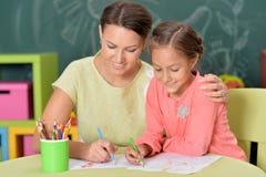 Portrait of mother with little daughter drawing with colorful pencils royalty free stock photography Portrait of mother with little daughter drawing with colorful pencils royalty free stock photography