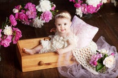 Portrait Of A Beautiful Little Baby Girl With Pink Flowers. Sweet Smiling Girl Sitting In Wooden Box On The Floor Stock Photos