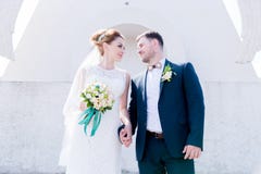 Portrait Of A Lovely Couple Honeymooned On A Wedding Day With A Bouquet In Hand Against The Background Of An Orthodox Royalty Free Stock Photo