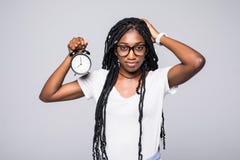 Portrait Of A Shocked Young Afro American Woman Holding Alarm Clock Isolated Over Gray Background Stock Image Portrait Of A Shocked Young Afro American Woman Holding Alarm Clock Isolated Over Gray Background Stock Image