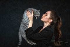 Portrait Of A Young Woman With A Cat On A Dark Background . Royalty Free Stock Photography