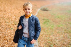 Portrait Of Cute Blonde Boy On A Walk In Autumn Park. Stylish Kid Outdoors. Kid Wearing Fashion Clothes Posing Outdoors. Autumn Royalty Free Stock Photos Portrait Of Cute Blonde Boy On A Walk In Autumn Park. Stylish Kid Outdoors. Kid Wearing Fashion Clothes Posing Outdoors. Autumn Royalty Free Stock Photos