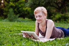 Portrait Of Middle Aged Woman Using Tablet In The Park Royalty Free Stock Images