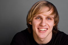Portrait Of Smiling Blond Man Over Gray Background Royalty Free Stock Image