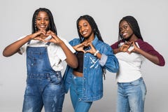 Portrait Of Three Beautiful African Women Smiling In Love Showing Heart Symbol And Shape With Hands Over White Isolated Background Stock Photos Portrait Of Three Beautiful African Women Smiling In Love Showing Heart Symbol And Shape With Hands Over White Isolated Background Stock Photos