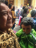 Elderly Woman Holds Baby Jesus during Pase del Niño Christmas Parade in Cuenca Ecuador royalty free stock photos Elderly Woman Holds Baby Jesus during Pase del Niño Christmas Parade in Cuenca Ecuador royalty free stock photos