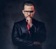 Portrait of a pensive stylish male in a black suit and red tie. stock photo Portrait of a pensive stylish male in a black suit and red tie. stock photo