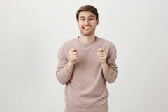Portrait playful attractive guy showing figs with both hands while sticking out tongue and smiling with satisfied stock photography Portrait playful attractive guy showing figs with both hands while sticking out tongue and smiling with satisfied stock photography