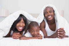 Portrait pretty couple with his son in bed together royalty free stock image Portrait pretty couple with his son in bed together royalty free stock image