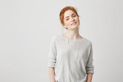 Portrait of pretty foxy girl listening to music in headphones smiling looking at camera over white background. Royalty Free Stock Images Portrait of pretty foxy girl listening to music in headphones smiling looking at camera over white background. Royalty Free Stock Images