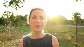 Portrait of pretty woman blows on reeds outdoors in sunny day. Fluff from reeds flies around. Slow motion stock footage Portrait of pretty woman blows on reeds outdoors in sunny day. Fluff from reeds flies around. Slow motion stock footage