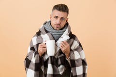 Portrait of a sad sick man wrapped in a blanket stock photo Portrait of a sad sick man wrapped in a blanket stock photo