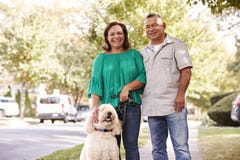Portrait Of Senior Couple Walking Dog Along Suburban Street stock photography Portrait Of Senior Couple Walking Dog Along Suburban Street stock photography