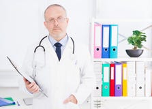 Portrait of senior doctor in medical office.Man in white uniform. Medical insurance. Copy space. Quality medicine concept. Copy sp royalty free stock image Portrait of senior doctor in medical office.Man in white uniform. Medical insurance. Copy space. Quality medicine concept. Copy sp royalty free stock image