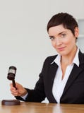 Portrait of a serious woman knocking a gavel royalty free stock photography Portrait of a serious woman knocking a gavel royalty free stock photography