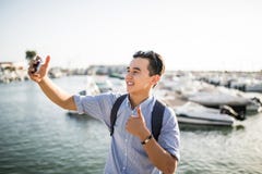 https://thumbs.dreamstime.com/t/portrait-smiling-asian-man-taking-selfie-thumbs-up-near-sea-boats-old-european-city-portrait-smiling-asian-man-96845036.jpg