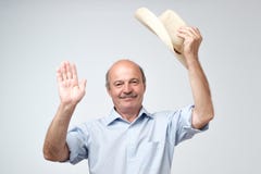Portrait of a smiling mature european man putting cowboy hat off and looking at camera. I am waiting to hear from you royalty free stock photos Portrait of a smiling mature european man putting cowboy hat off and looking at camera. I am waiting to hear from you royalty free stock photos