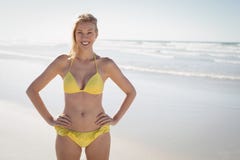 Portrait of smiling young woman in yellow bikini standing at beach stock image Portrait of smiling young woman in yellow bikini standing at beach stock image