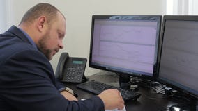The portrait of successful trader who works in his private office looking at the monnitors. stock video The portrait of successful trader who works in his private office looking at the monnitors. stock video