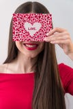 Portrait of a sweet perfect girl smiling at camera with heart shaped paper in her hands. Valentine`s Day or Women`s Day stock photos Portrait of a sweet perfect girl smiling at camera with heart shaped paper in her hands. Valentine`s Day or Women`s Day stock photos