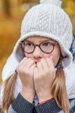 Portrait of teenage girl in glasses, blowing on her hands to keep warm in the cold royalty free stock images Portrait of teenage girl in glasses, blowing on her hands to keep warm in the cold royalty free stock images