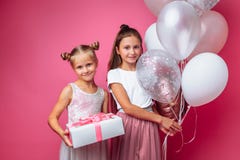Portrait of a teenage girl on a pink background, with gifts, birthday concept, one gives another girl a gift royalty free stock photography Portrait of a teenage girl on a pink background, with gifts, birthday concept, one gives another girl a gift royalty free stock photography