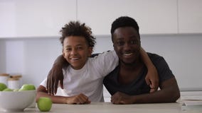 Portrait of two people smiling dad and son looking at camera Spbi. happy family on kitchen. teen