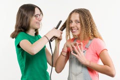 Portrait of two teenage girlfriends doing hairstyle at home. royalty free stock image Portrait of two teenage girlfriends doing hairstyle at home. royalty free stock image
