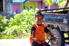 Portrait of unknown smiling asian child sitting on a bicycle
