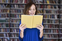 Portrait of woman over 25 in a library reading an opened book, concentrated and smart. Young college student in co-working, concep royalty free stock photos Portrait of woman over 25 in a library reading an opened book, concentrated and smart. Young college student in co-working, concep royalty free stock photos