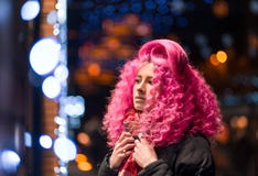 Portrait young attractive caucasian girl model with afro style curly bright pink hair, tattooed face. Evening downtown walking royalty free stock image Portrait young attractive caucasian girl model with afro style curly bright pink hair, tattooed face. Evening downtown walking royalty free stock image