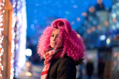 Portrait young attractive caucasian girl model with afro style curly bright pink hair, tattooed face. Evening downtown walking royalty free stock images Portrait young attractive caucasian girl model with afro style curly bright pink hair, tattooed face. Evening downtown walking royalty free stock images