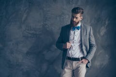 Portrait of young bearded guy in a suit stands on a gray backgro stock photography Portrait of young bearded guy in a suit stands on a gray backgro stock photography