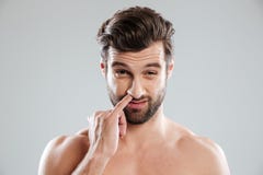 Portrait of a young bearded naked man picking his nose royalty free stock image Portrait of a young bearded naked man picking his nose royalty free stock image