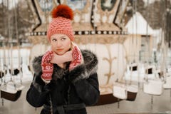 Portrait of young blond woman in winter clothes. Red cap and mittens. Walking in the park royalty free stock photos Portrait of young blond woman in winter clothes. Red cap and mittens. Walking in the park royalty free stock photos