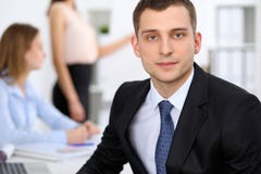 Portrait of a young business man against a group of business people at a meeting. Royalty Free Stock Photo Portrait of a young business man against a group of business people at a meeting. Royalty Free Stock Photo