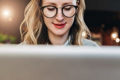 Portrait of young business woman in trendy glasses sitting in cafe,working on laptop.Blogger communicates with followers royalty free stock images Portrait of young business woman in trendy glasses sitting in cafe,working on laptop.Blogger communicates with followers royalty free stock images