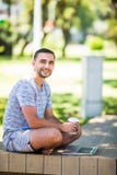 Portrait of young happy man with laptop and cup of coffee on bench in park royalty free stock images Portrait of young happy man with laptop and cup of coffee on bench in park royalty free stock images