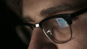 Portrait of a young man with glasses who works at night. Close up stock video footage Portrait of a young man with glasses who works at night. Close up stock video footage
