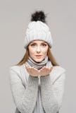 Portrait of a young and beautiful woman in a winter hat over grey background. royalty free stock images Portrait of a young and beautiful woman in a winter hat over grey background. royalty free stock images