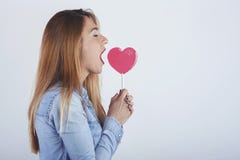 Portrait of young woman with heart shaped lollipop royalty free stock images Portrait of young woman with heart shaped lollipop royalty free stock images
