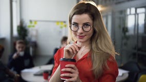 Portrait of young woman looking at the camera smiling while touches glasses Attractive woman wearing glasses in the stock video footage Portrait of young woman looking at the camera smiling while touches glasses Attractive woman wearing glasses in the stock video footage