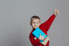 Portret atrakcyjna uśmiechnięta chłopiec w czerwonym pulowerze z książkami w górę obraz stock Portret atrakcyjna uśmiechnięta chłopiec w czerwonym pulowerze z książkami w górę obraz stock